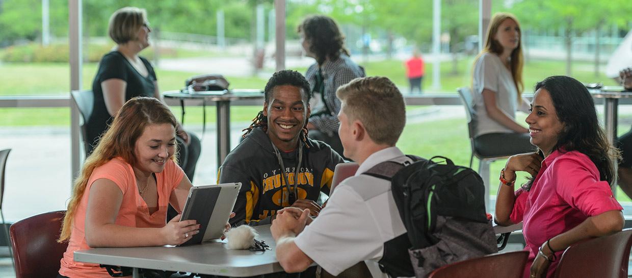 学生s sitting at a table in the campus center